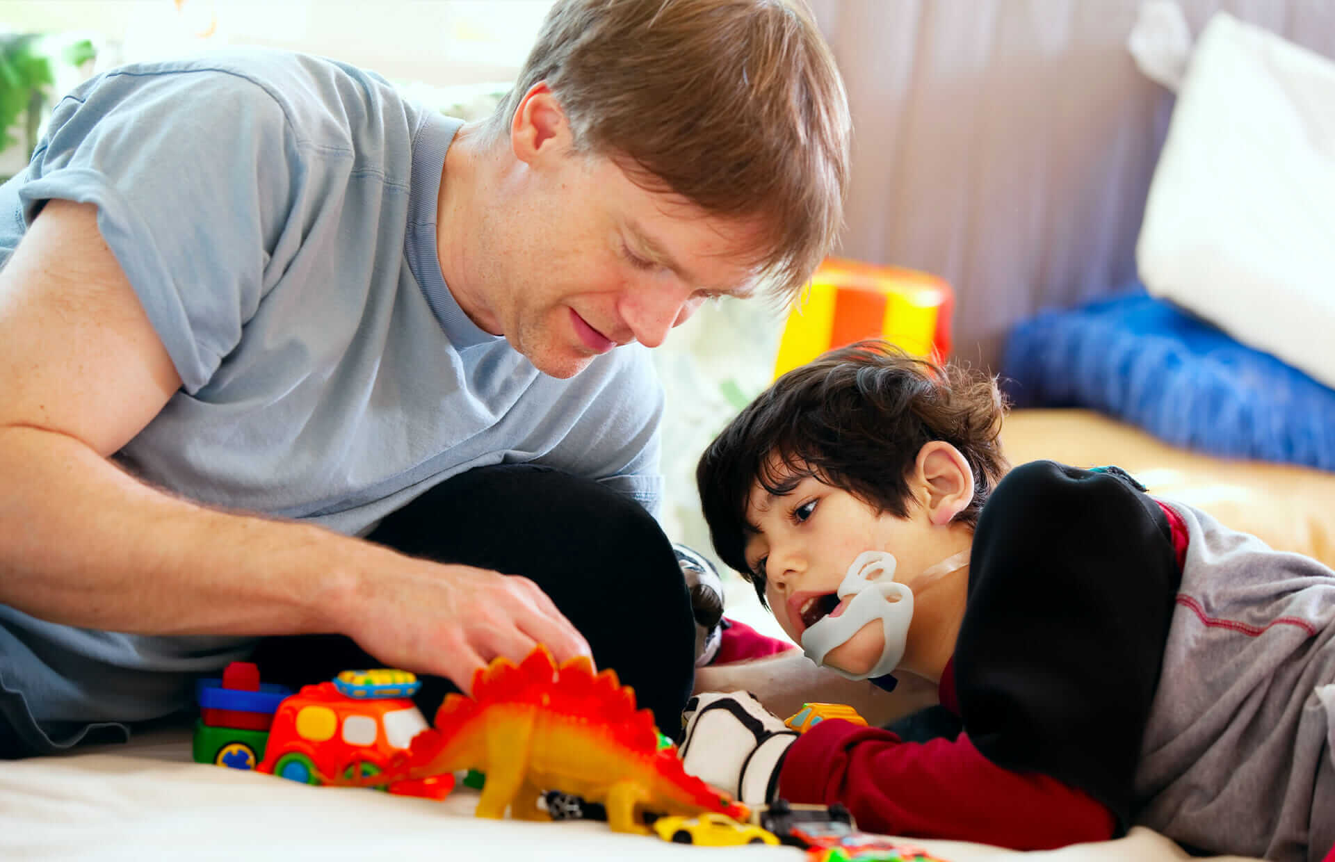 Father and disabled son playing on floor