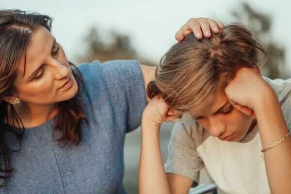 Mother consoling upset teenage son
